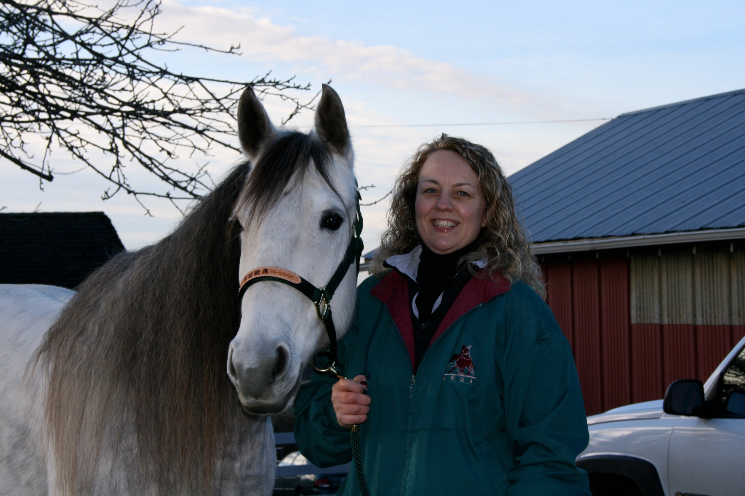 Karen Pickering standing beside her gray horse, April, in Bellingham, Washington.